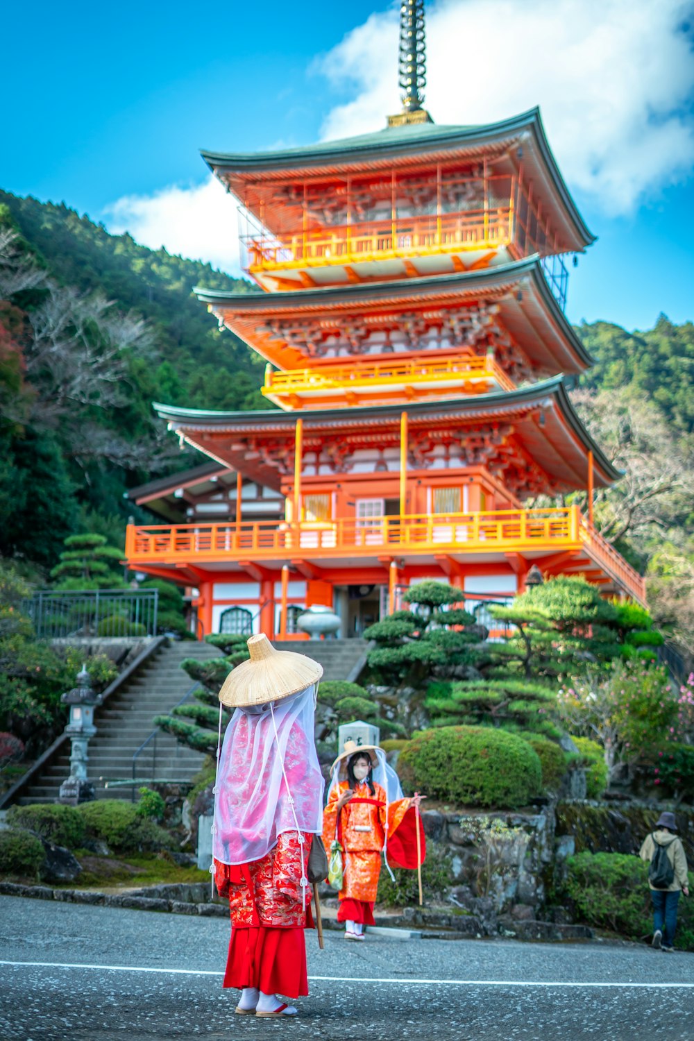 a woman with an umbrella standing in front of a tall building