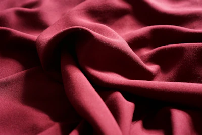 Elegant wine-colored velvet fabric with soft glowing lights to convey sophistication and sensuality.