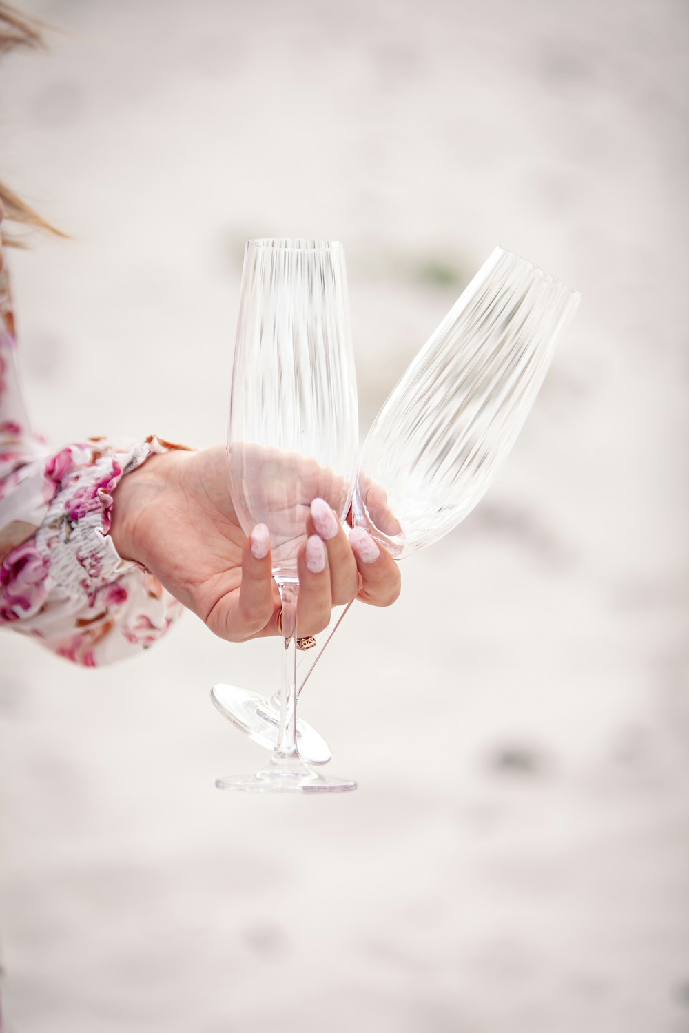 a woman holding two wine glasses in her hand