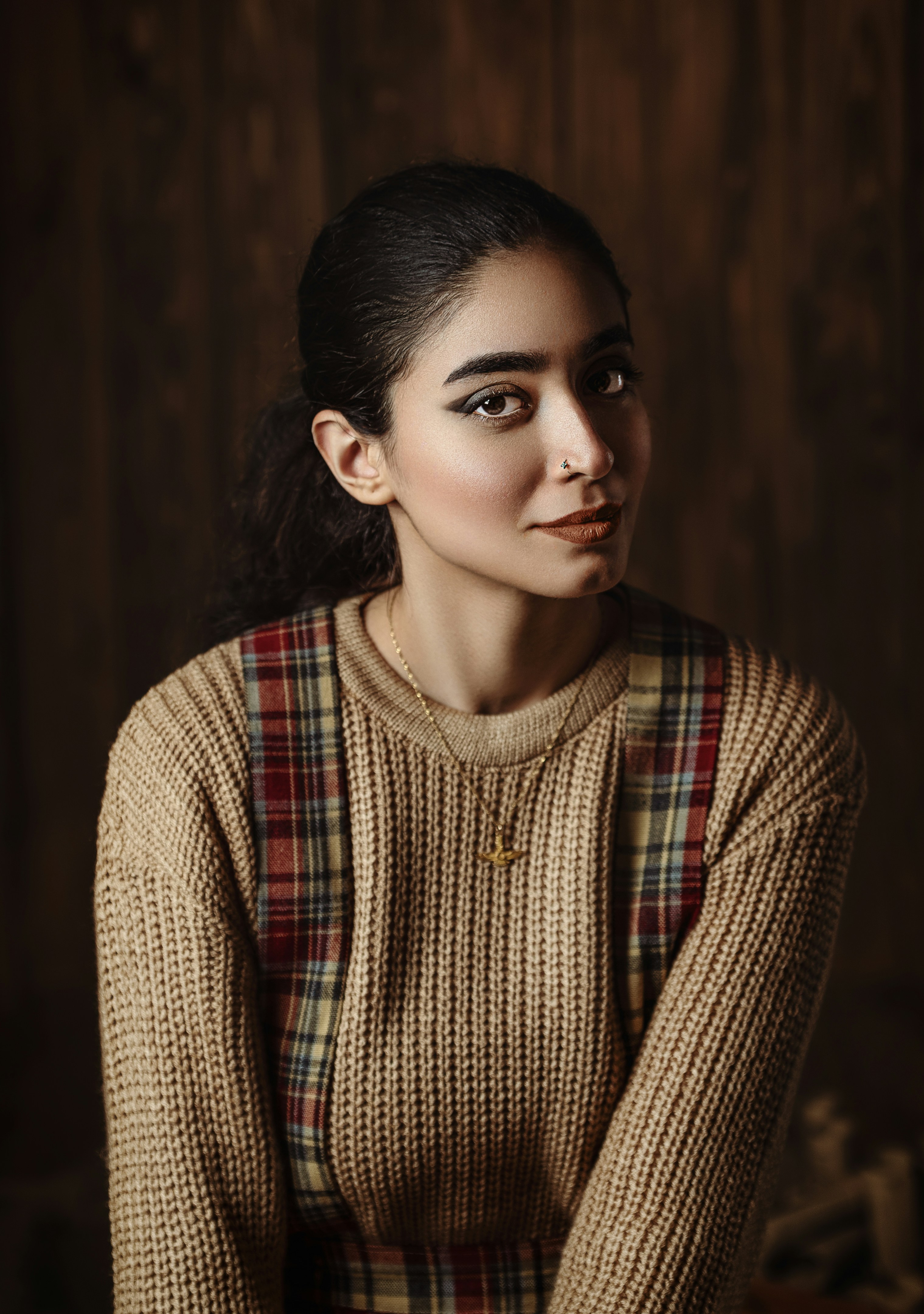 A woman in a sweater is posing for a picture
