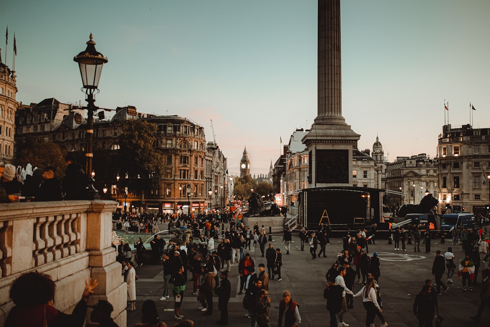 a crowd of people walking around a city square