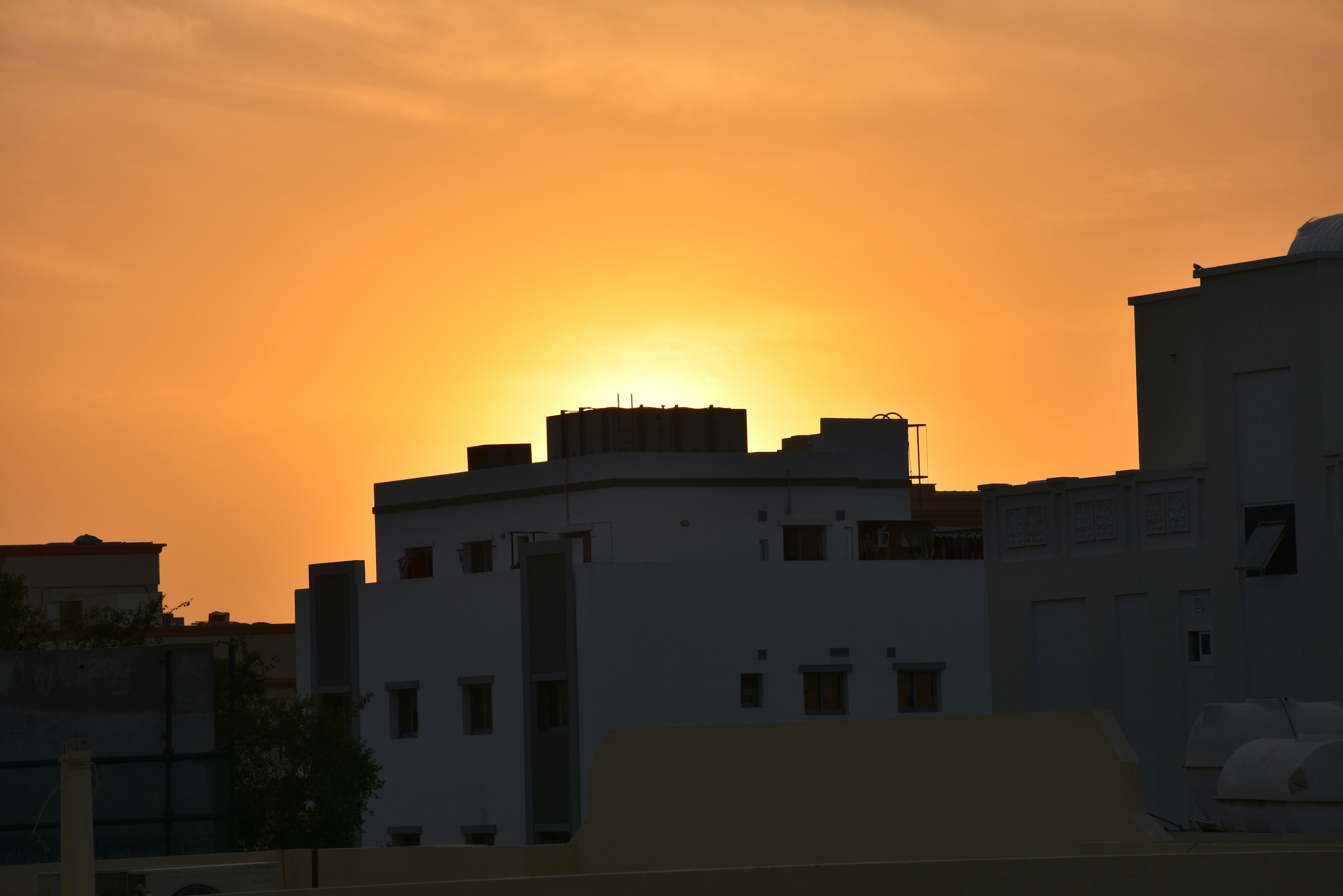 the sun is setting over a city skyline