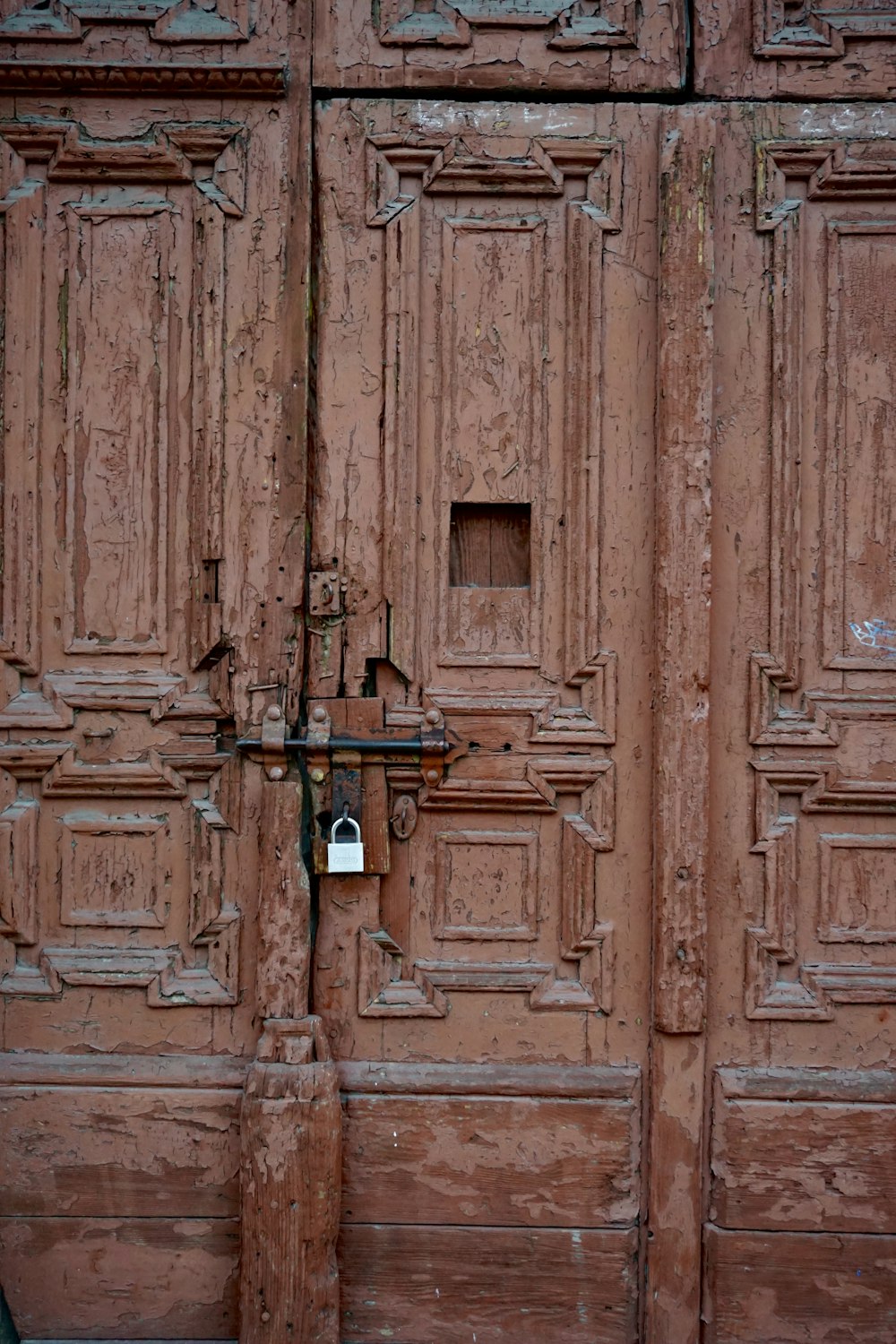 an old wooden door with a padlock on it