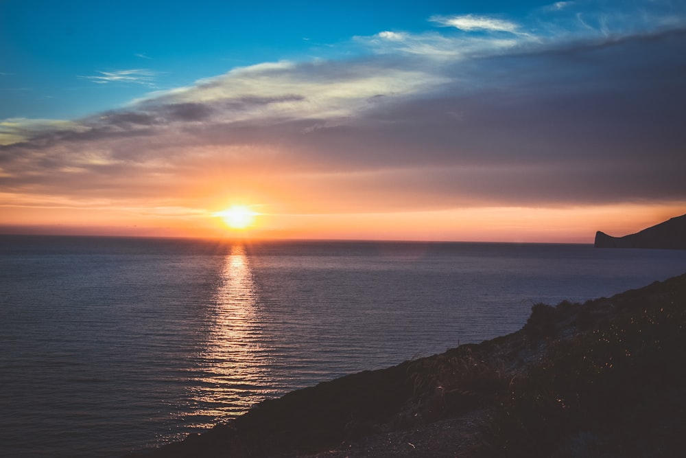 Il sole sta tramontando sull'oceano in una giornata nuvolosa