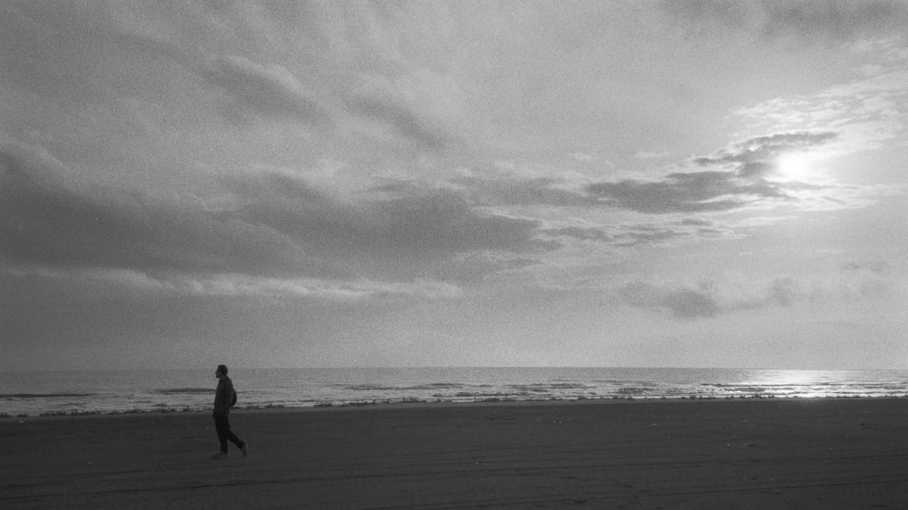 a person walking on a beach near the ocean