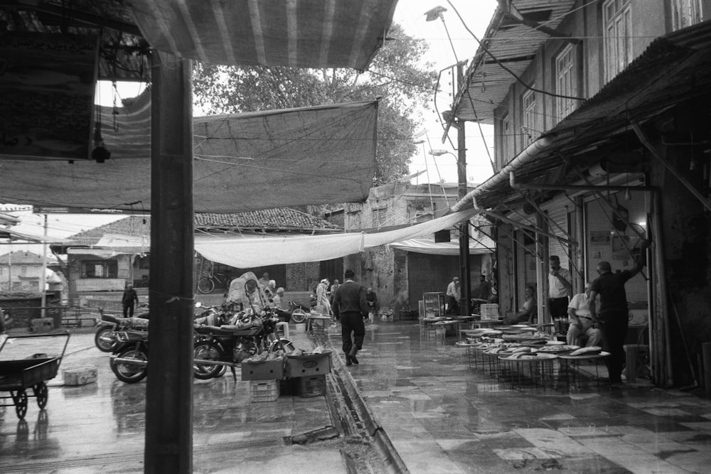 a black and white photo of people walking down a street