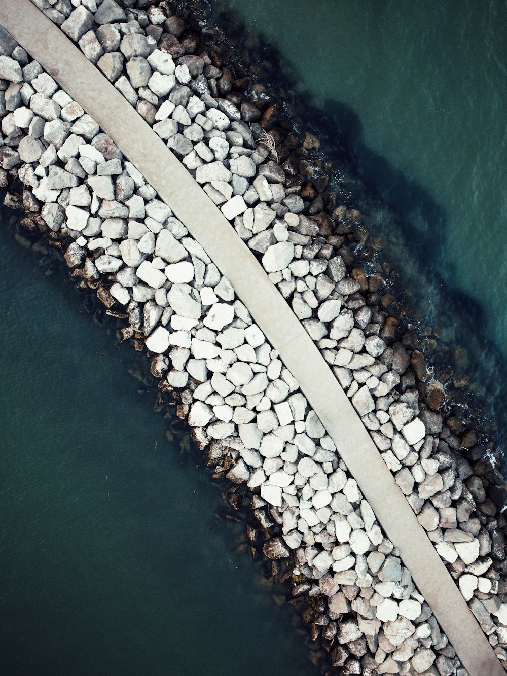 an aerial view of a road and a body of water