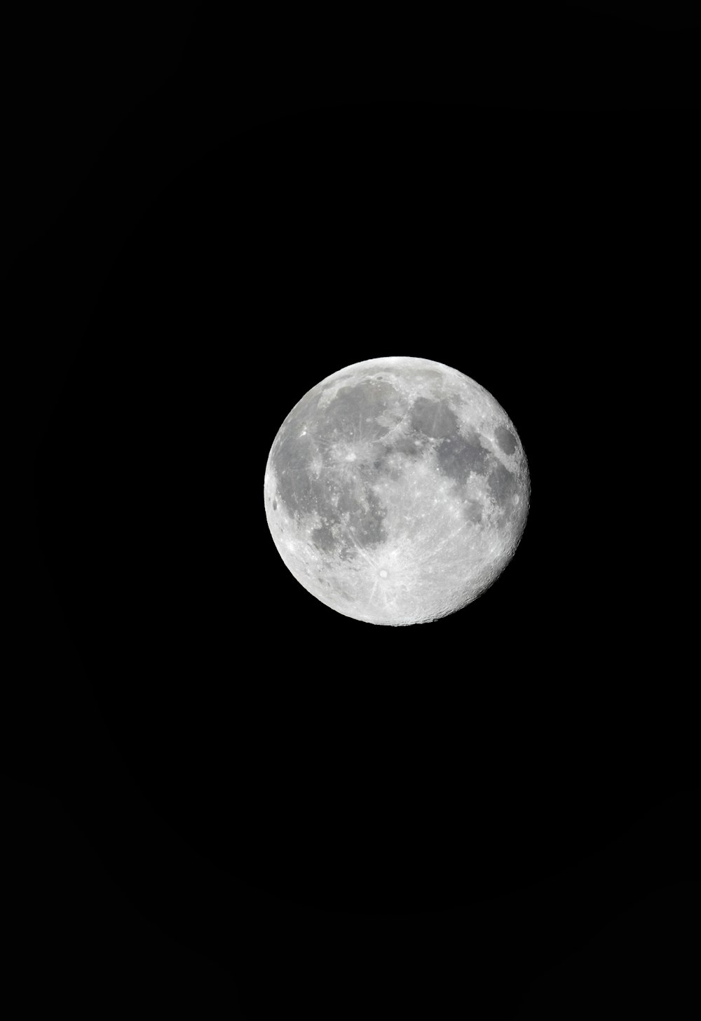 Una luna llena se ve en el cielo oscuro