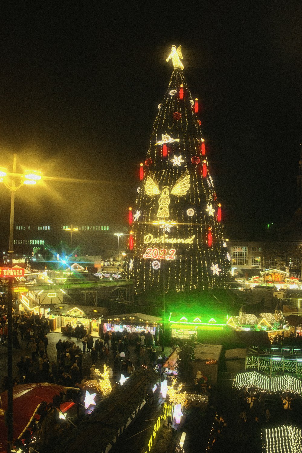 a large christmas tree is lit up at night