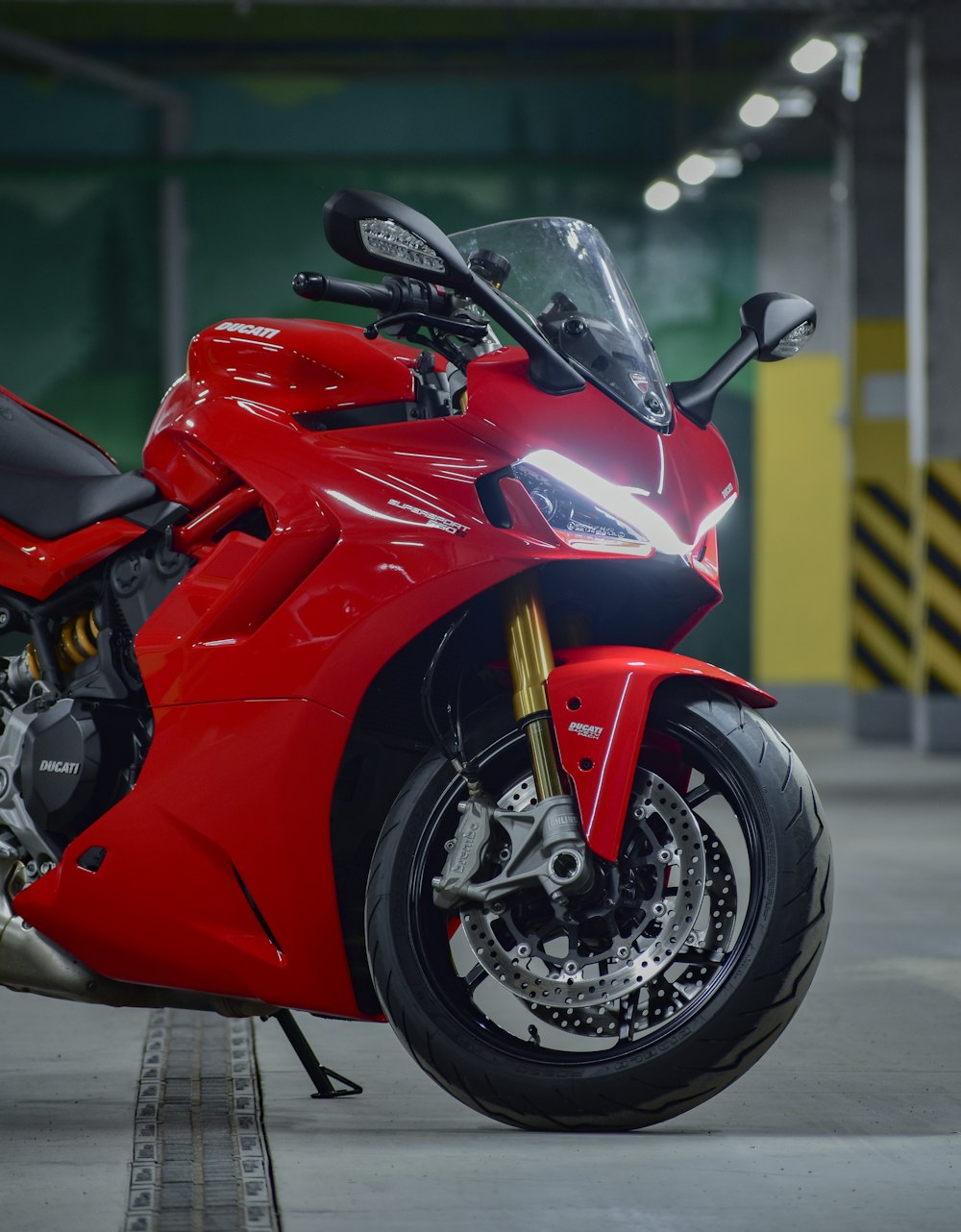 a red motorcycle parked inside of a garage