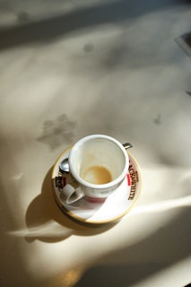 A sunlit terrace with empty chairs and a single coffee cup, evoking quiet moments.