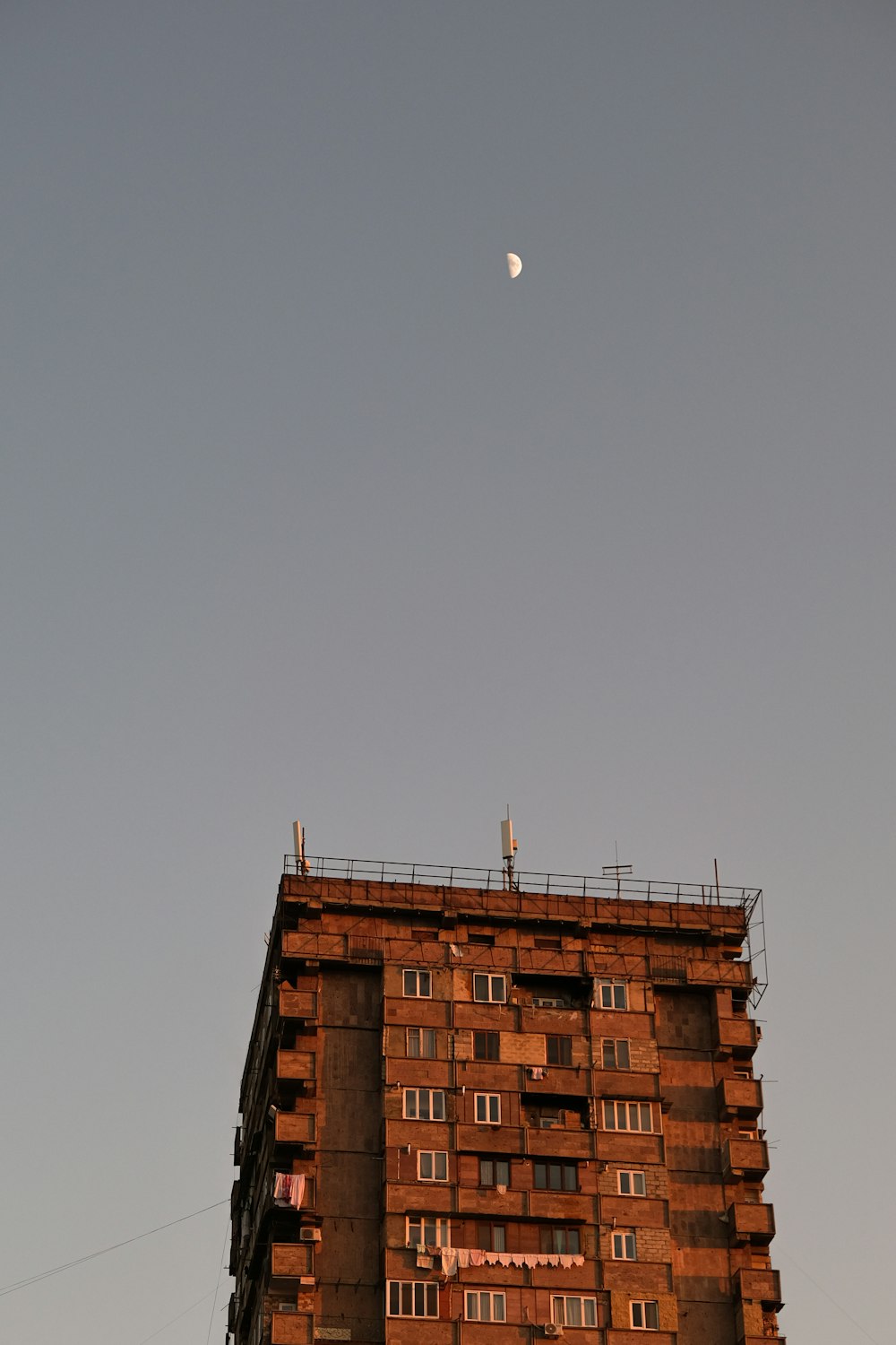 a tall brick building with a half moon in the sky