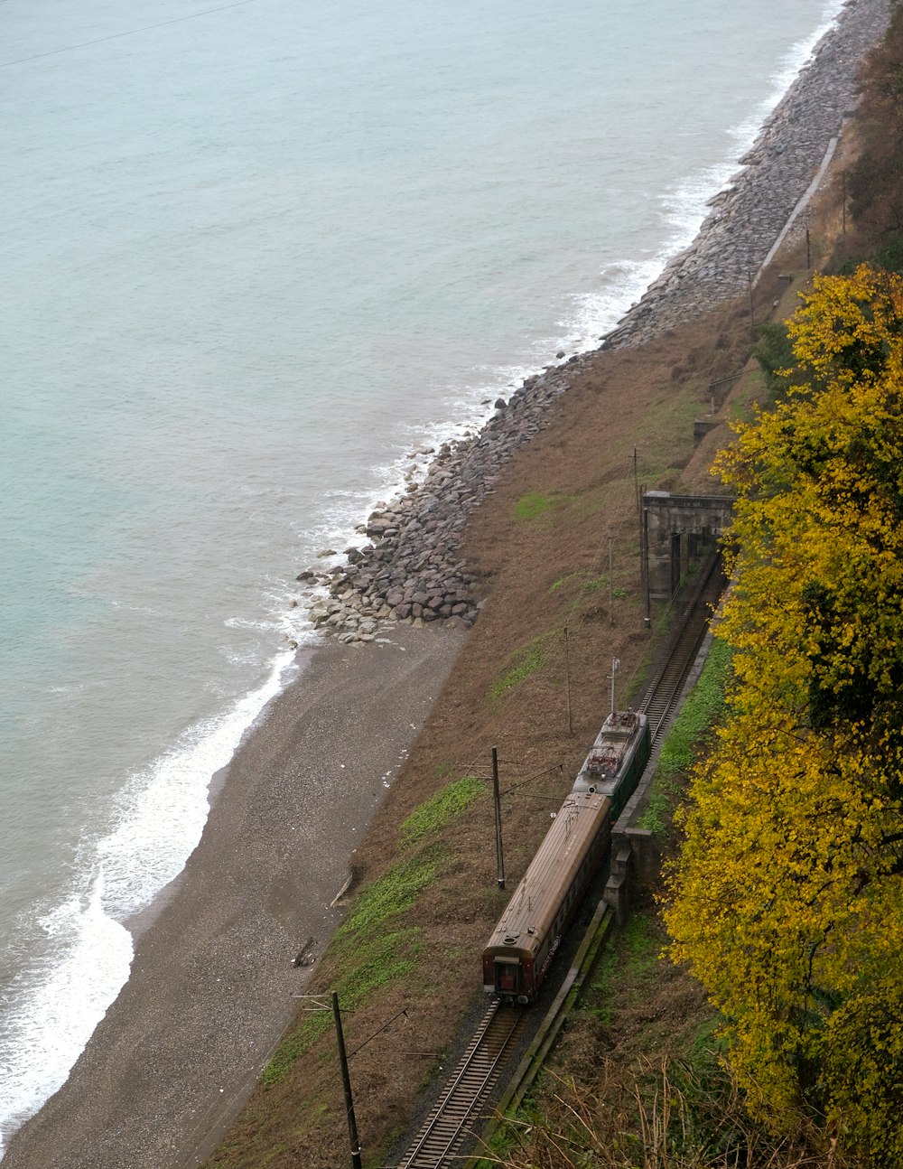 a train traveling down tracks next to a beach