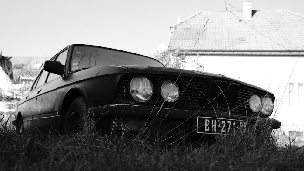 a black and white photo of a car in the grass