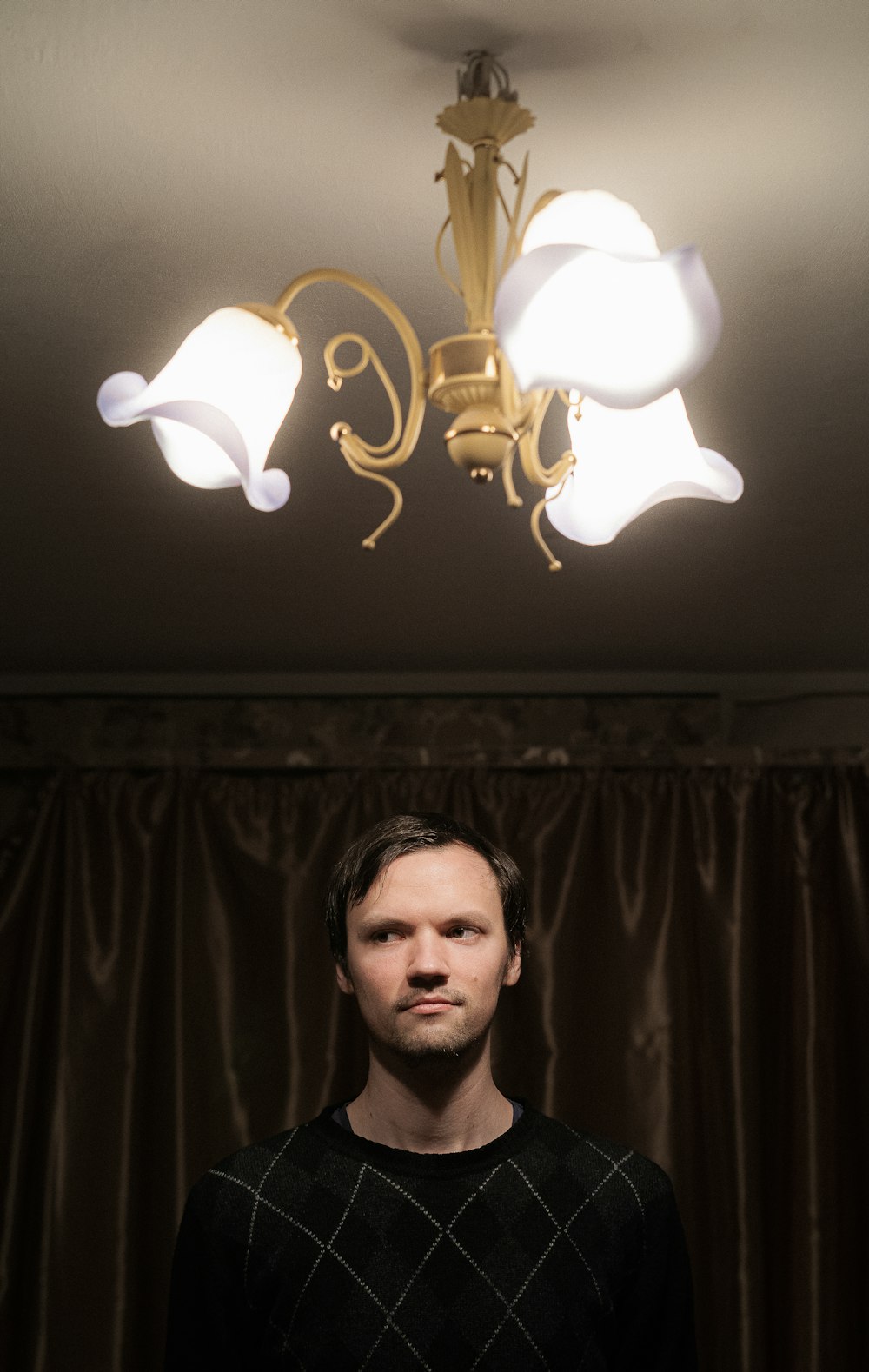 a man standing in front of a chandelier