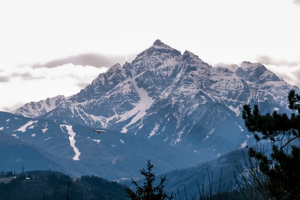 a mountain range with a plane flying over it