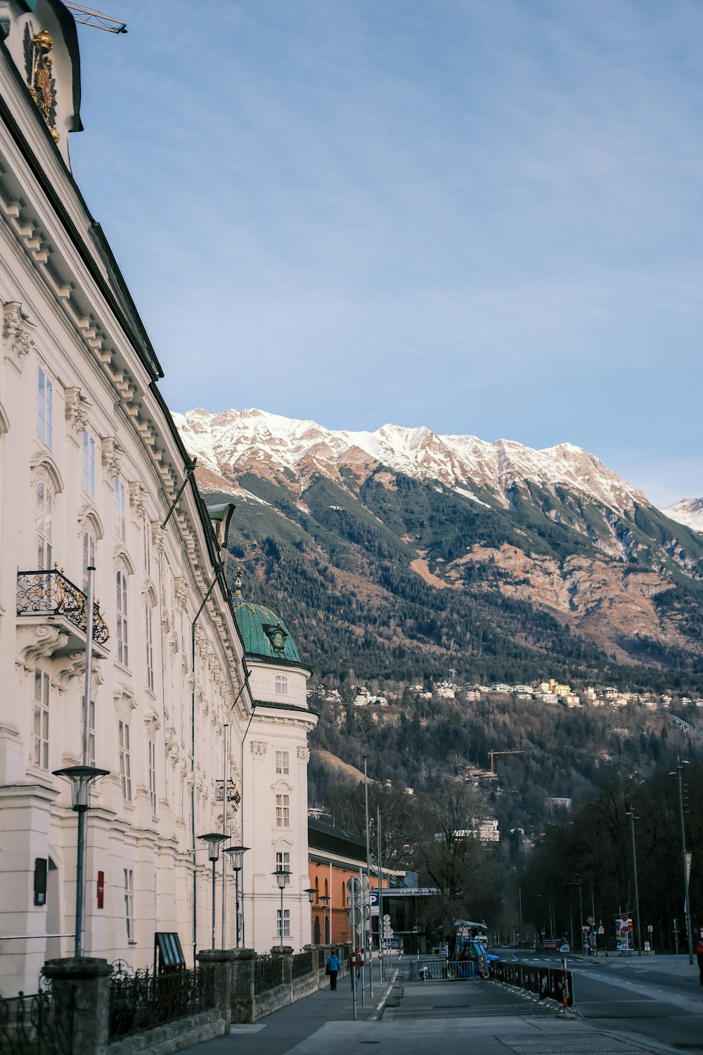 a large white building with a mountain in the background