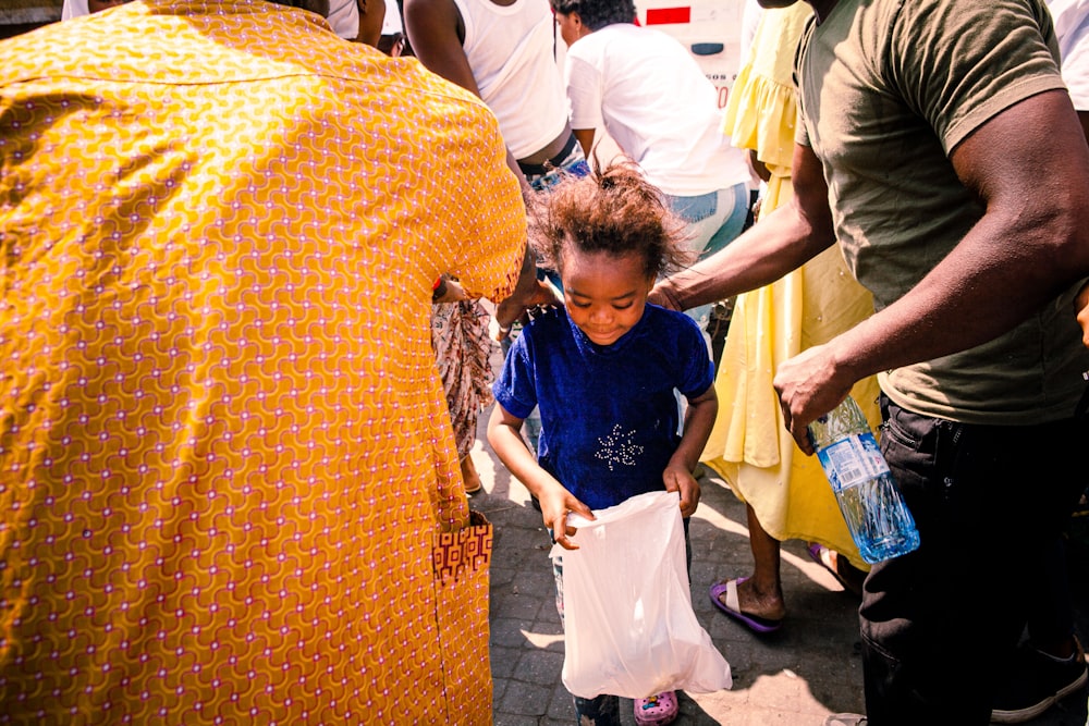 a little girl holding a white bag in her hands