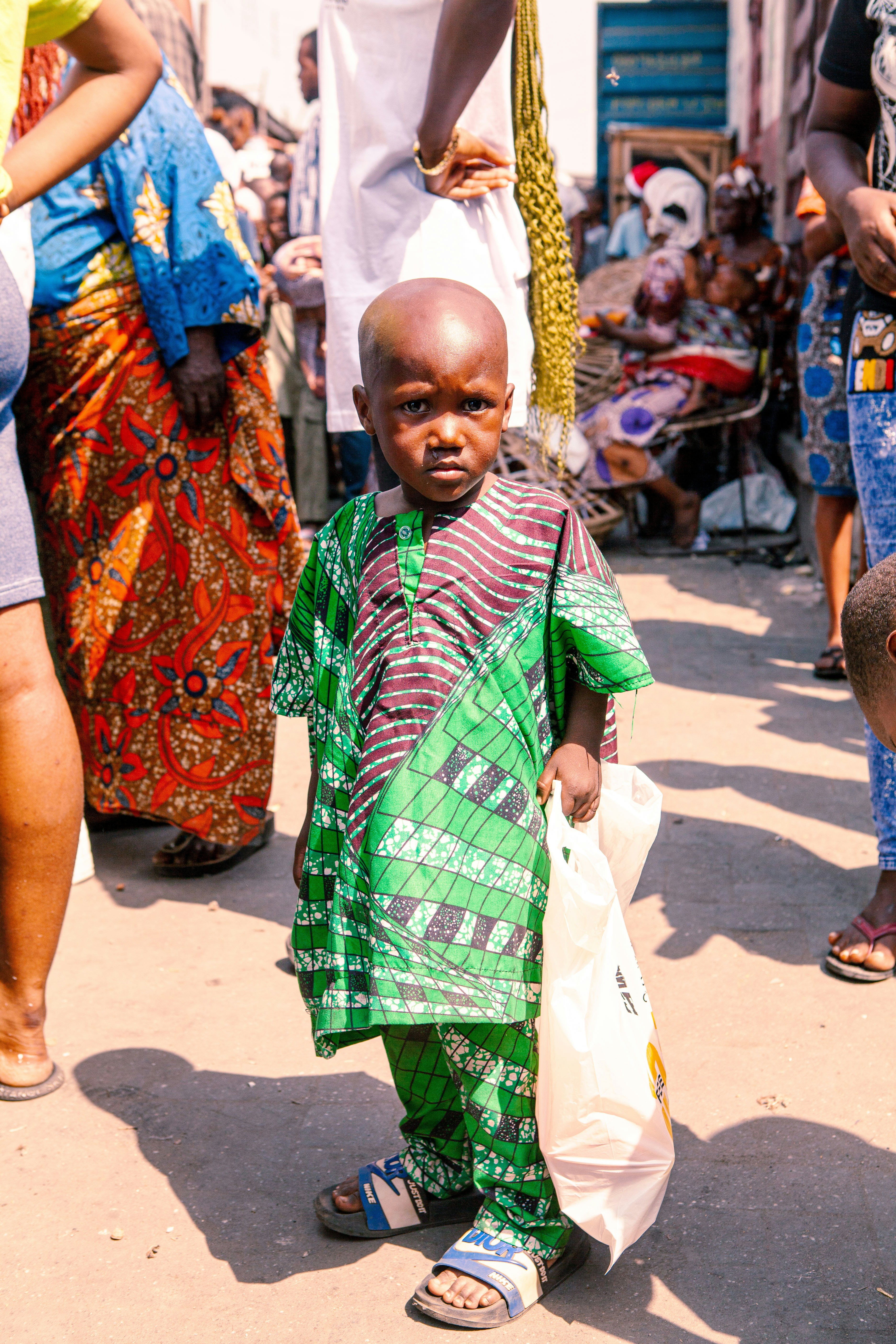 a little boy in a green and red outfit