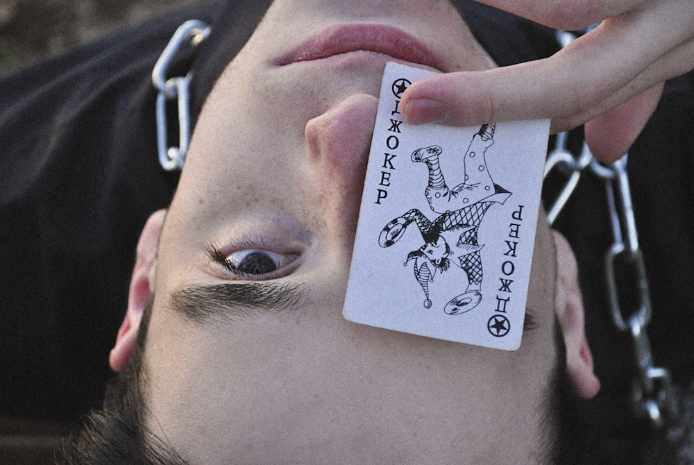 a man holding a card with a chain around his neck