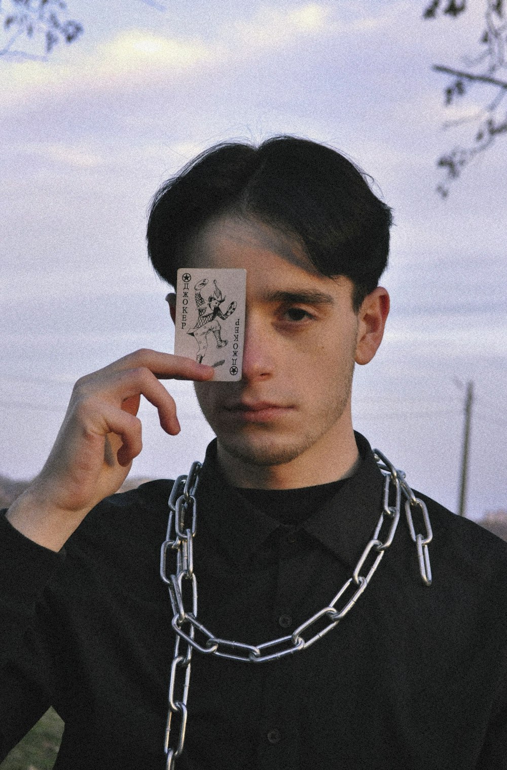 a man holding up a card with a chain around his neck