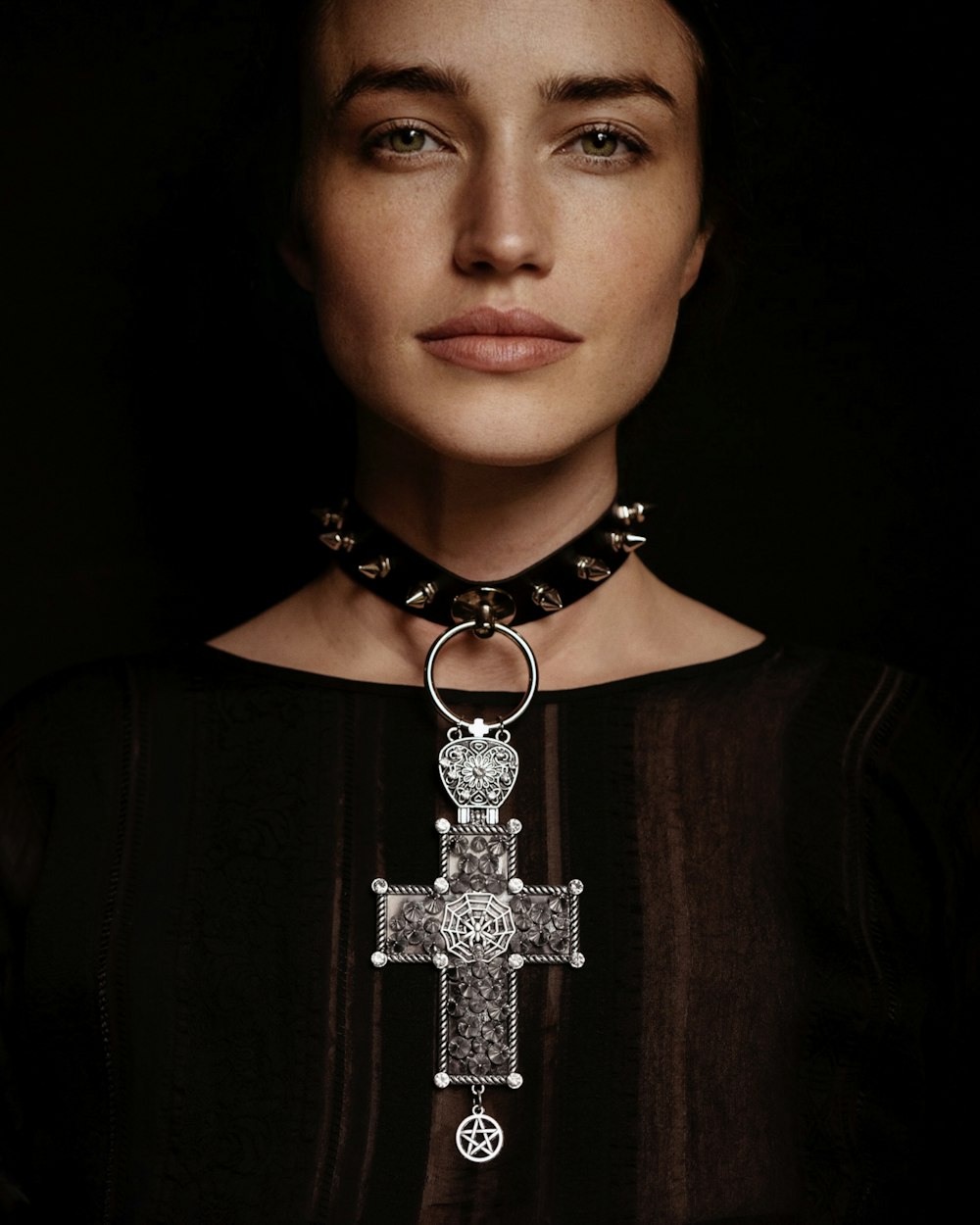 uma mulher vestindo um colar com uma cruz sobre ele