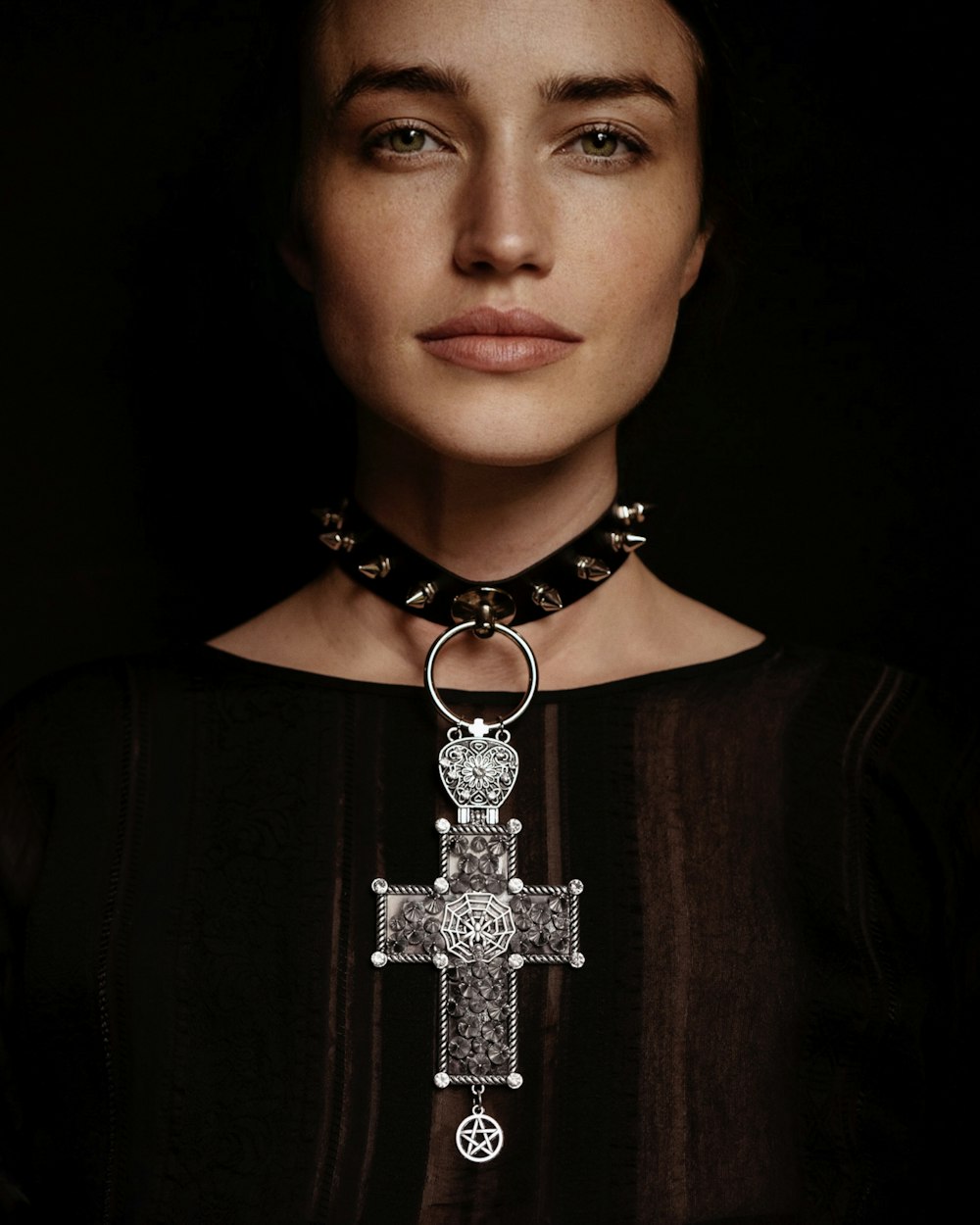 a woman wearing a necklace with a cross on it