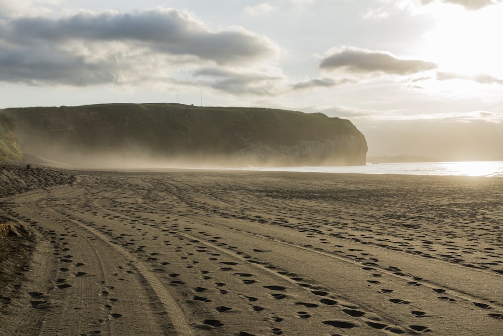 a sandy beach with footprints in the sand