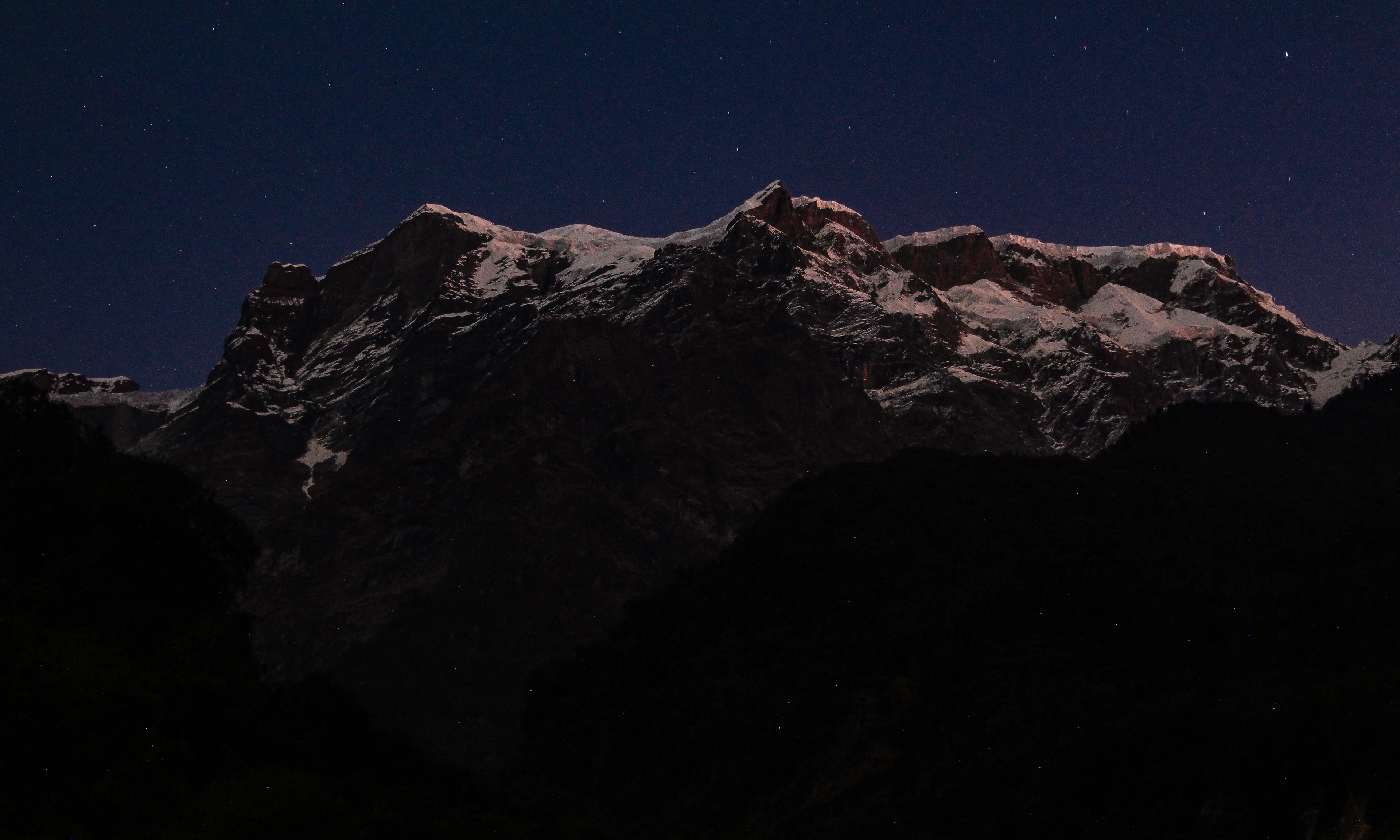 Stars over a dark mountain range