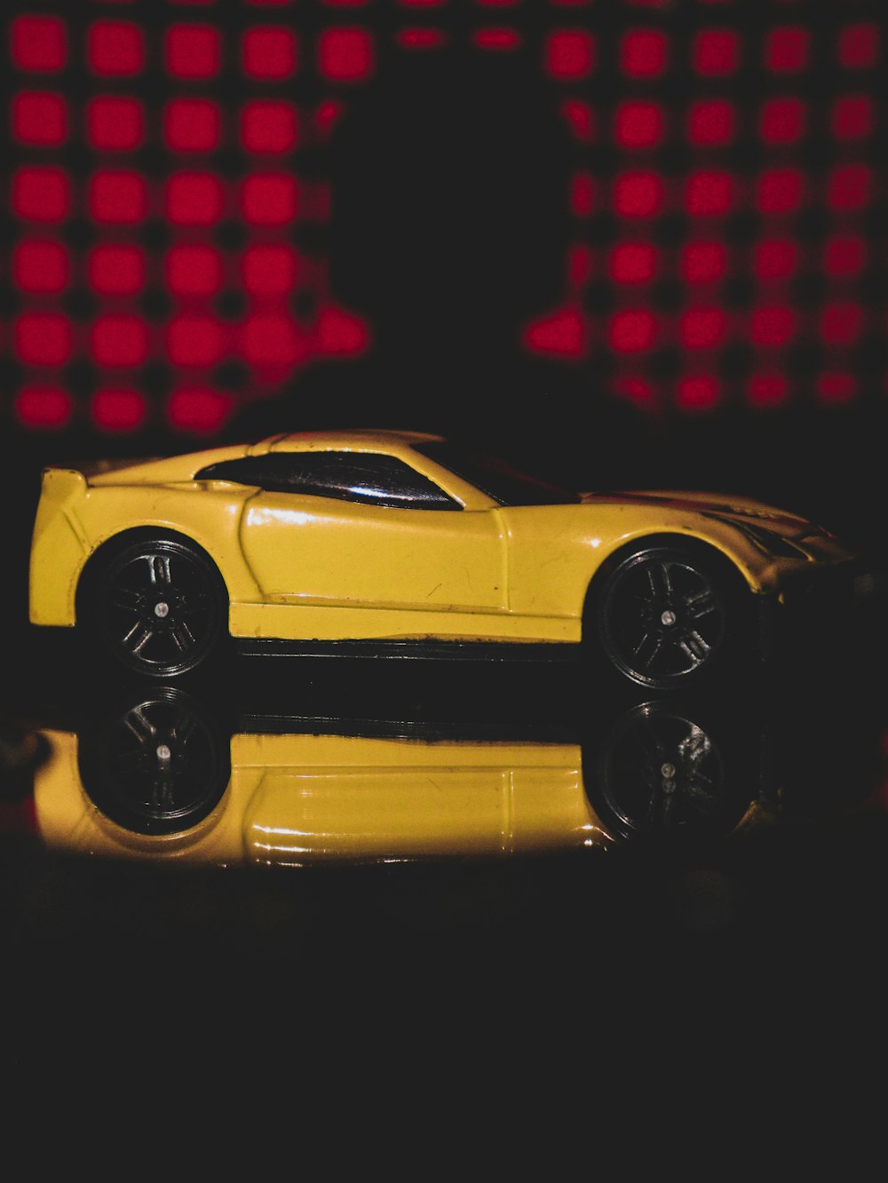 a yellow toy car sitting on top of a table