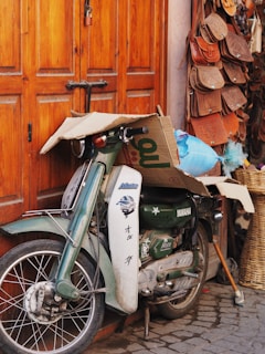 A close-up shot of a vintage motorcycle parked beside a stack of classic vinyl records and film reels.