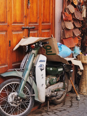 A close-up shot of a vintage motorcycle parked beside a stack of classic vinyl records and film reels.