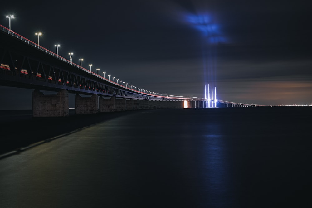 a long bridge over a body of water at night