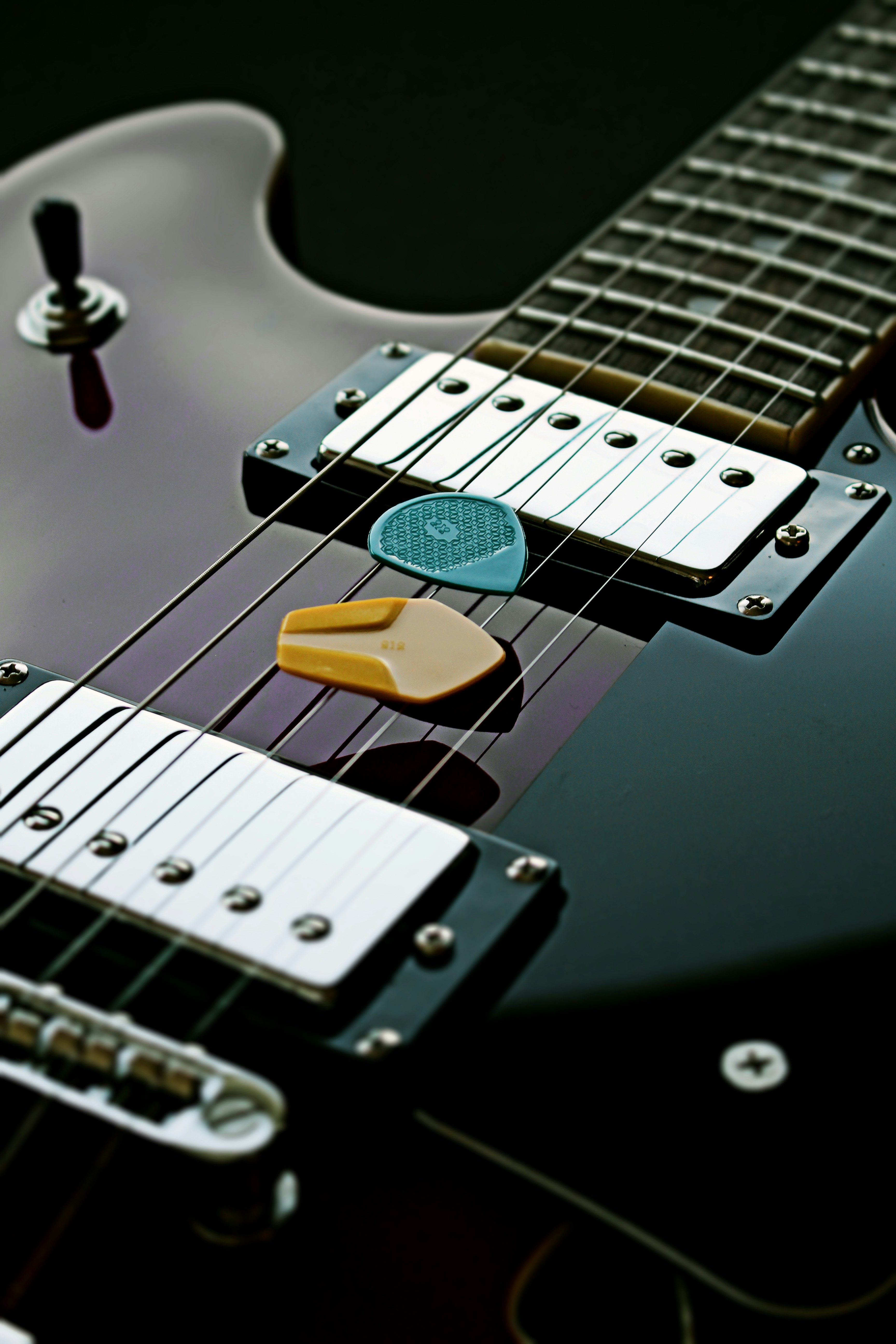 a close up of a guitar picker on a black guitar