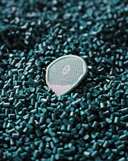 a close up of a tennis racket laying on a pile of green tiles