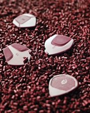 Several geometric objects with labels are scattered on a surface covered with small red cylindrical pellets. The objects appear to be white with maroon sections.