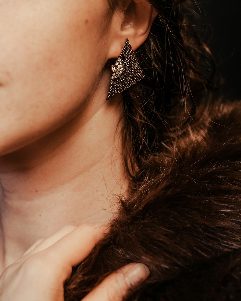 a close up of a person wearing a pair of earrings