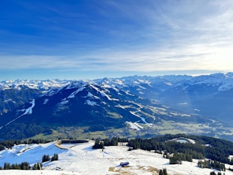 A panoramic view of the snow-capped peaks of the Swiss Alps under a bright blue sky