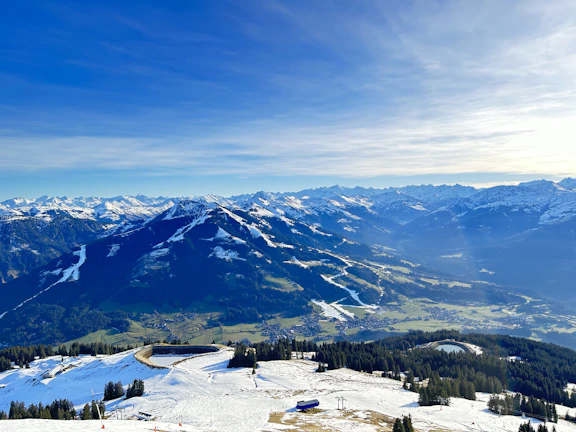 A panoramic view of Saint Moritz's snow-covered mountains under a clear blue sky.