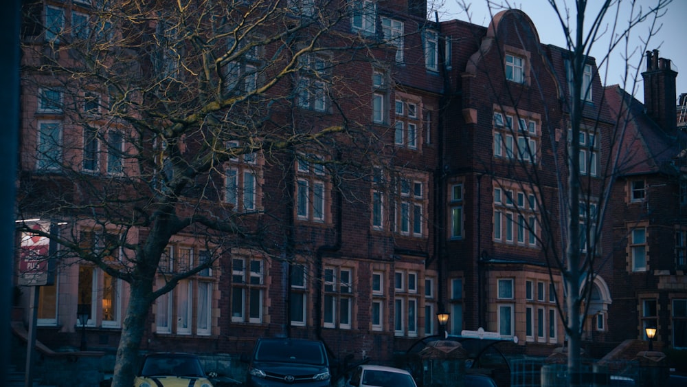 cars parked in front of a large brick building