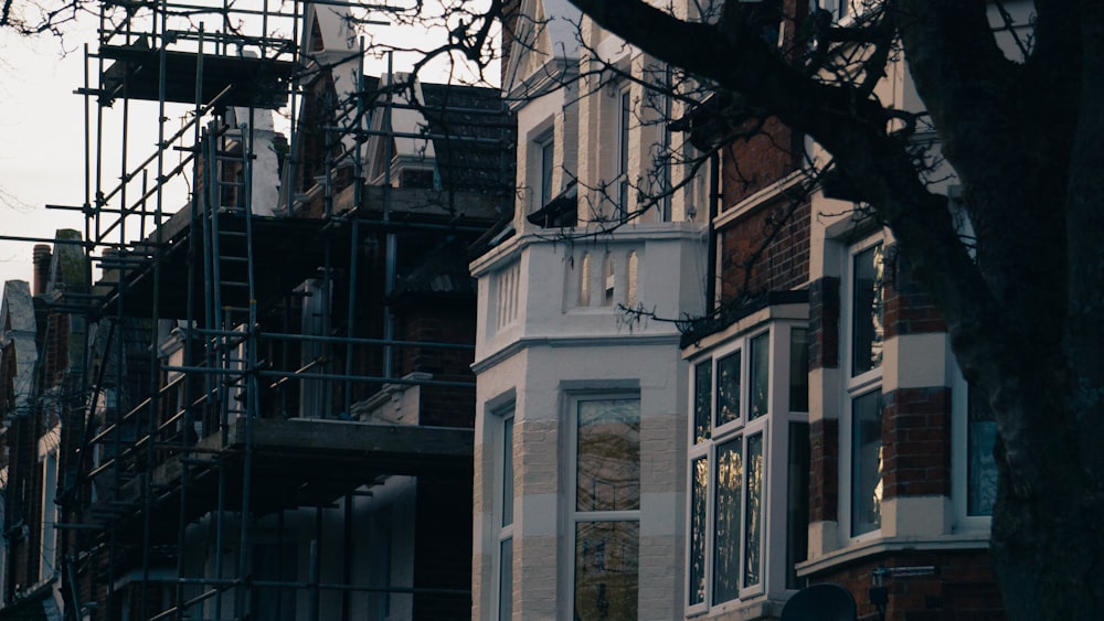 a row of houses with scaffolding on the windows