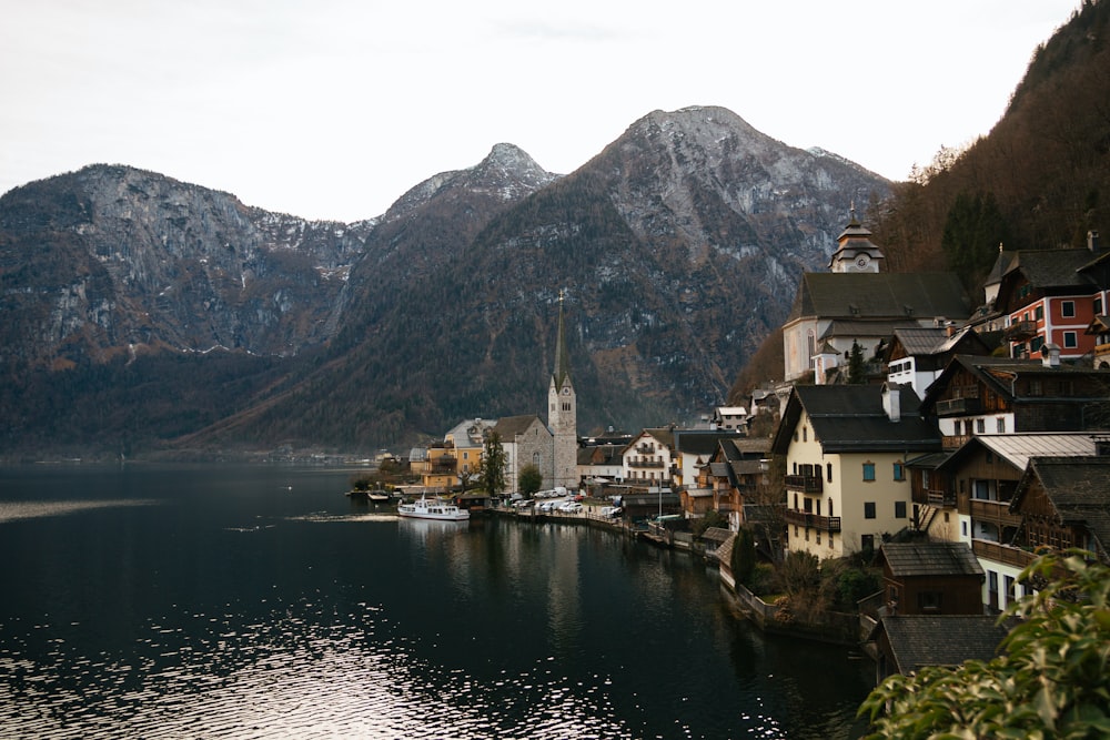 a village on a lake with mountains in the background