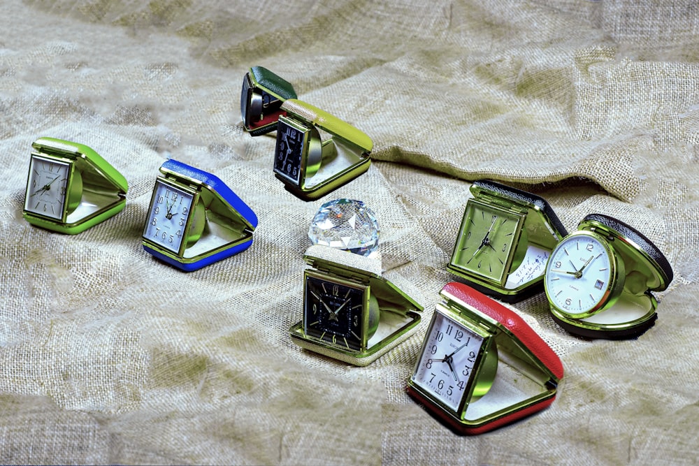un gruppo di piccoli orologi seduti in cima a un tavolo