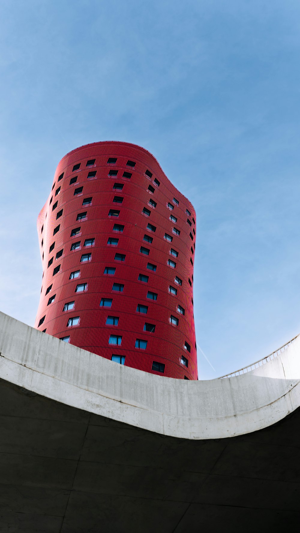 a tall red building sitting on the side of a bridge