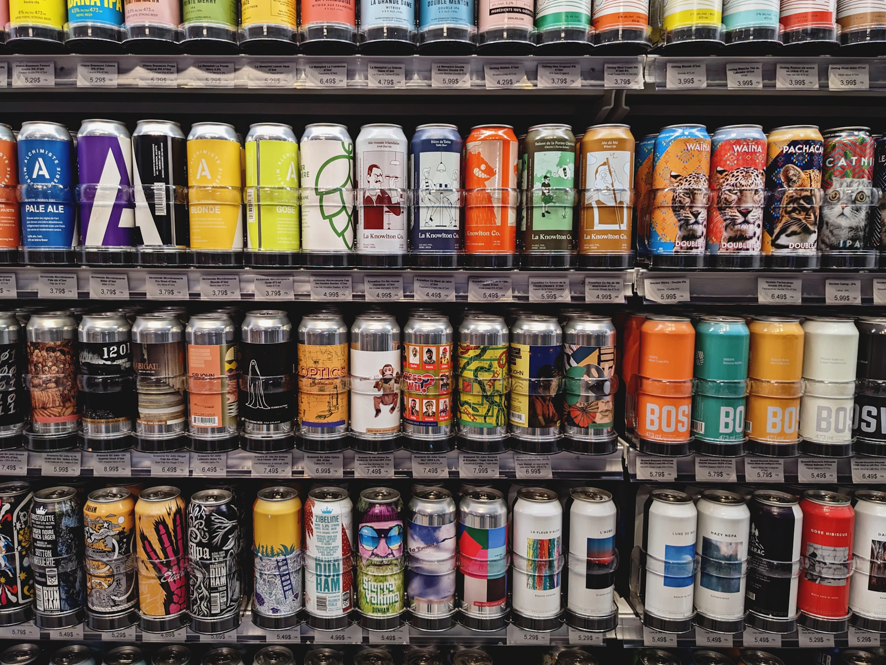 Craft beer cans lined up label forward on four store shelves