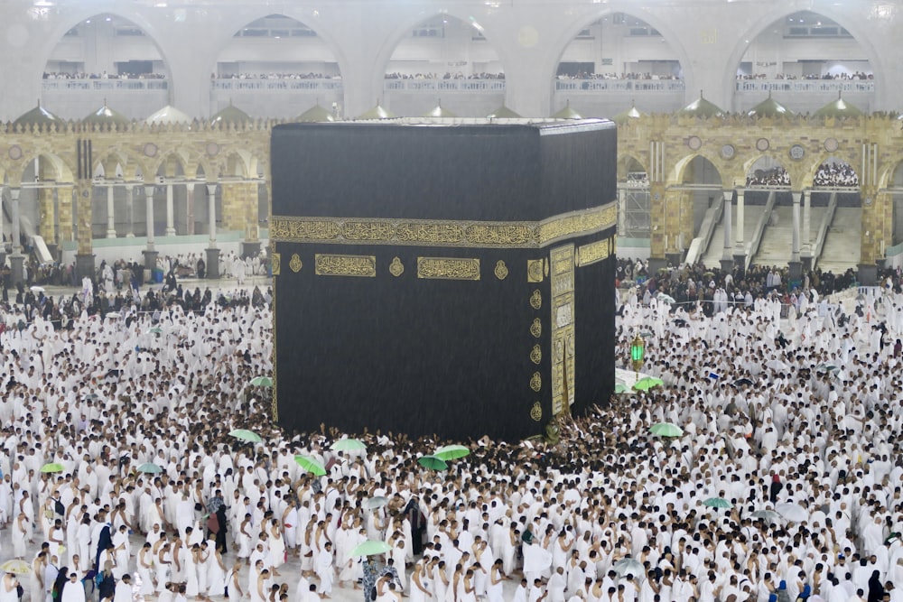 a large group of people surrounding a large black and gold building