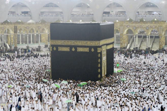 a large group of people surrounding a large black and gold building