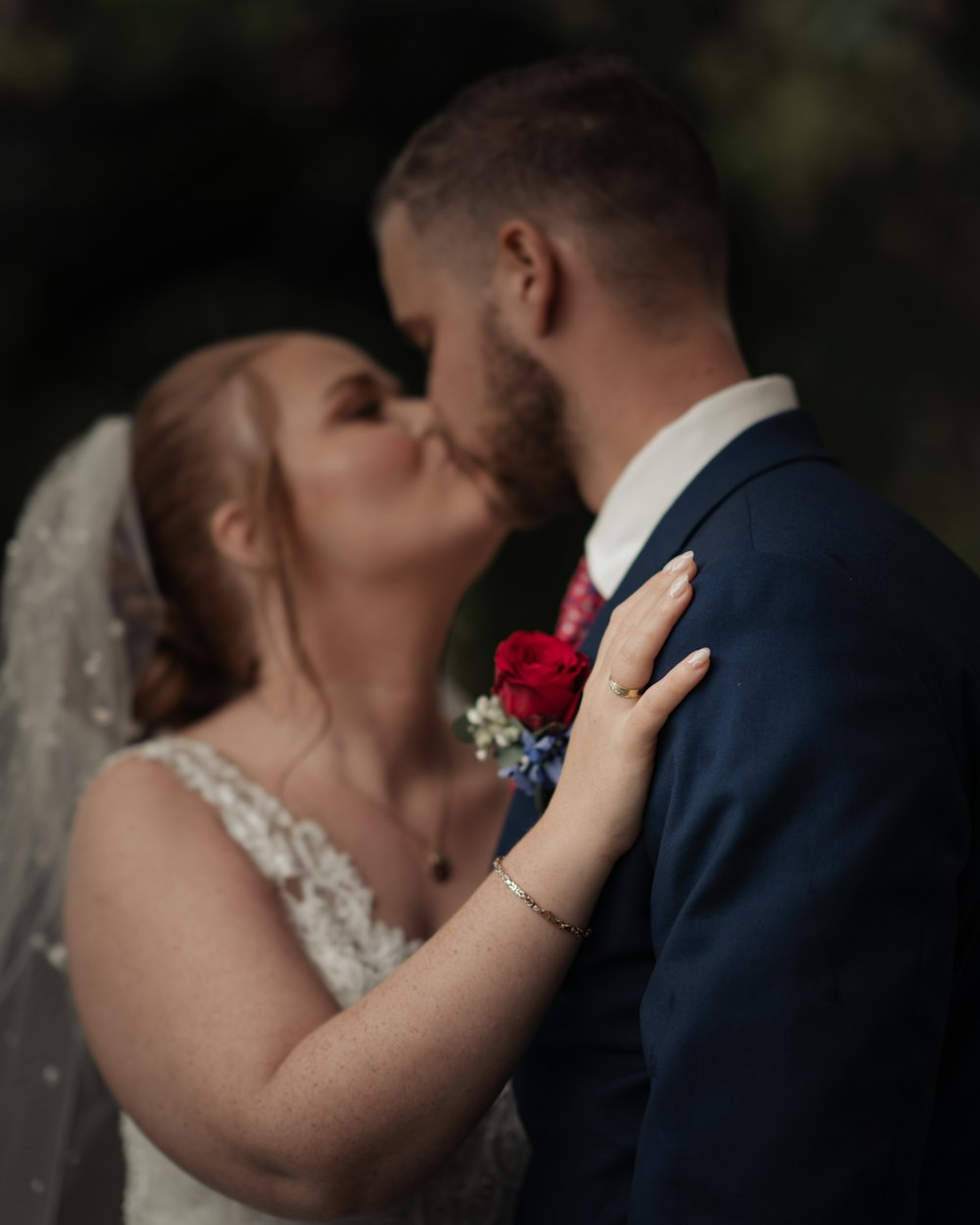 a bride and groom kissing in front of a tree