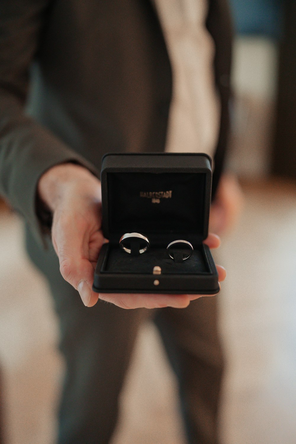 a person holding a ring in a box