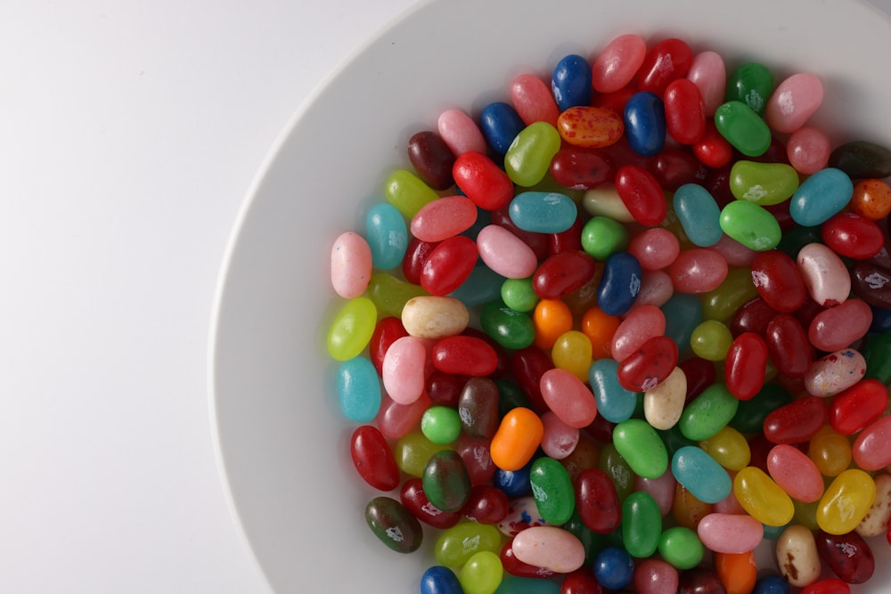 a white bowl filled with jelly beans on top of a table